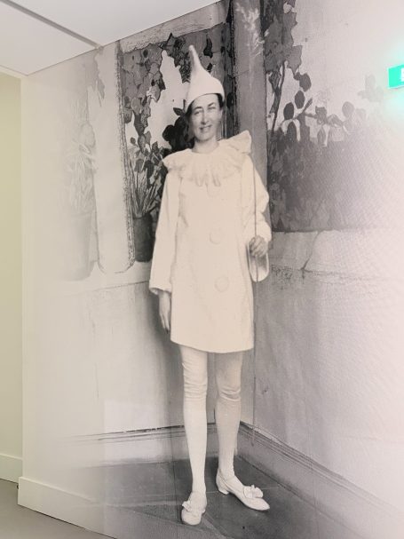 Ein historisches Foto eines clownähnlichen Kindes in einem weißen Kostüm.