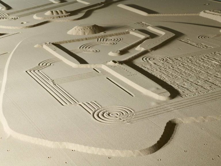 Helle Sandstruktur mit geometrischen Formen und verschiedenen Landschaftselementen.