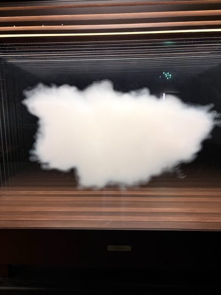 Weiße, fluffige Wolkenformation vor einem dunklen Hintergrund.