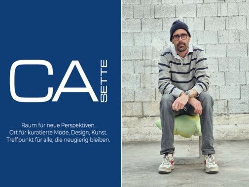 Mann mit Brille und gestreiftem Pullover sitzt auf einem Hocker vor einer Mauer.