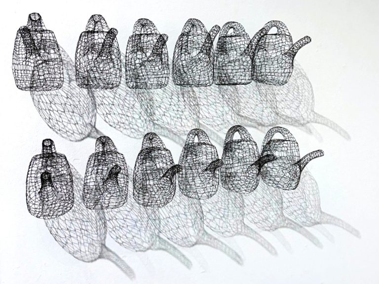 Mehrere durchsichtige Teekannen in einem geometrischen Muster angeordnet.
