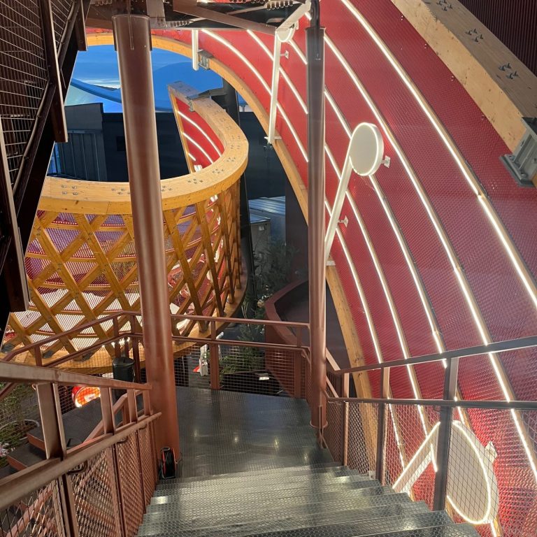 Treppenhaus mit beleuchteten Wänden und sportlichem Design, das an Leichtathletik erinnert.