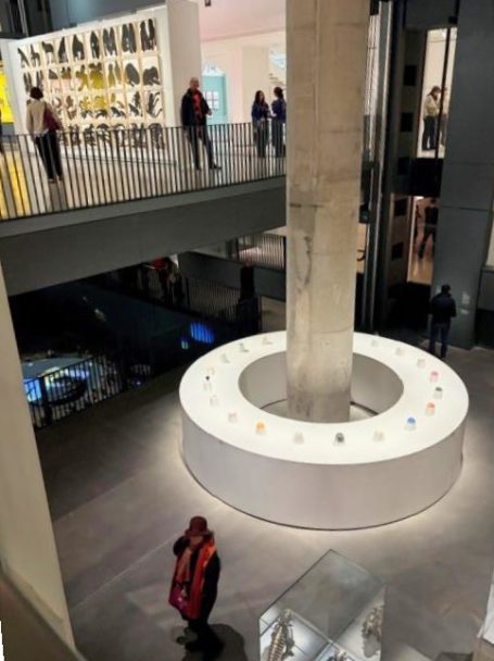 Moderne Ausstellung mit einem runden Display und Besuchern in einem weitläufigen Raum.