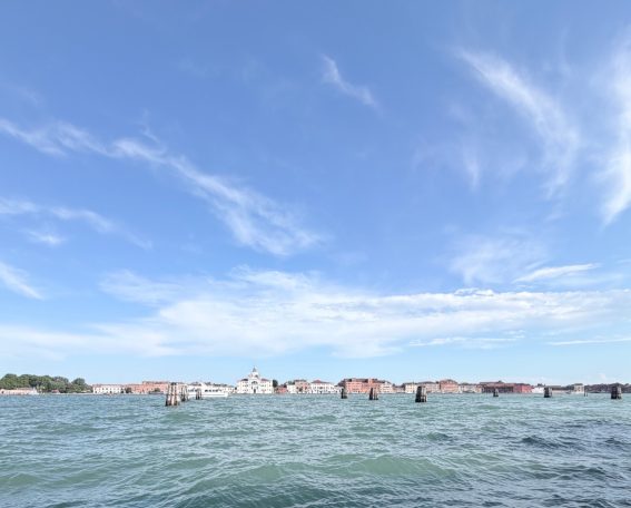 Blick auf eine Wasserlandschaft mit Gebäuden und blauem Himmel.