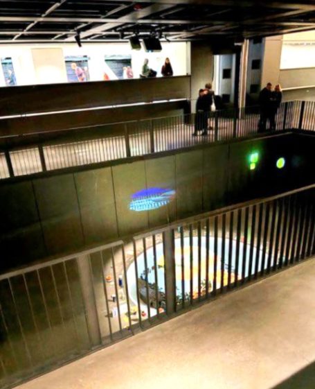 Ein moderner Innenraum mit verandertem Geländer und bunten Lichtern auf dem Boden.