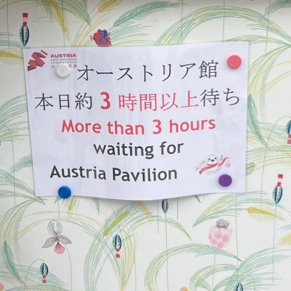 Schild mit Wartezeit von mehr als 3 Stunden für das Österreich-Pavillon.