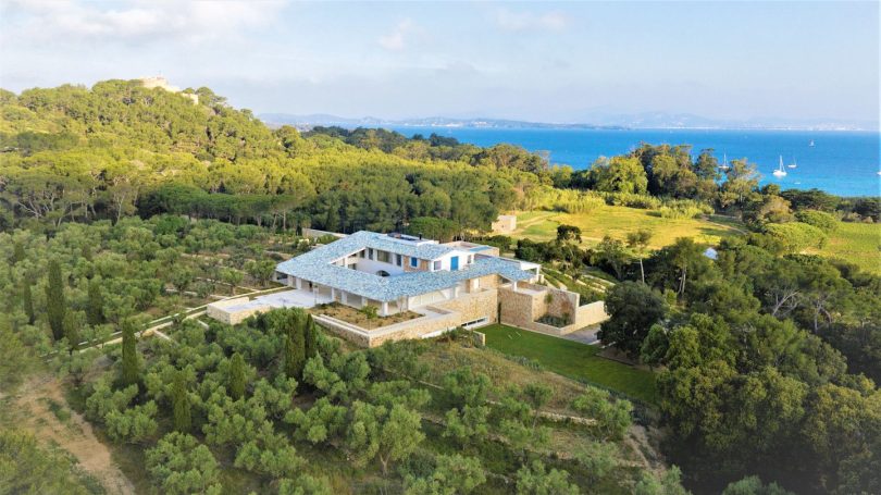 Moderne Villa umgeben von Bäumen mit Blick auf das Meer und die Küste.