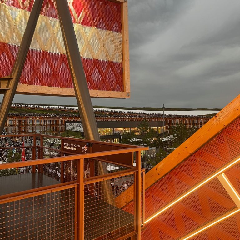 Blick auf eine farbenfrohe Struktur und Landschaft unter grauem Himmel.