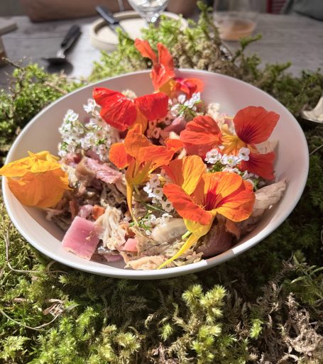 ein Teiller mit Essen und darauf bunte Blüten