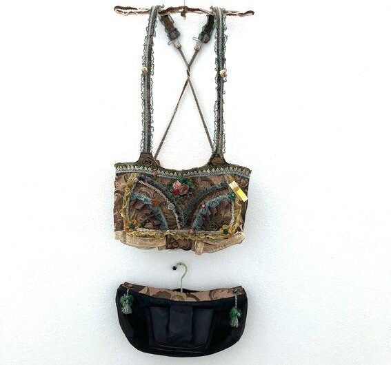 Traditionelles, verziertes Bustier mit breiten Trägern und Bunten Perlen, darunter eine kleine Tasche.