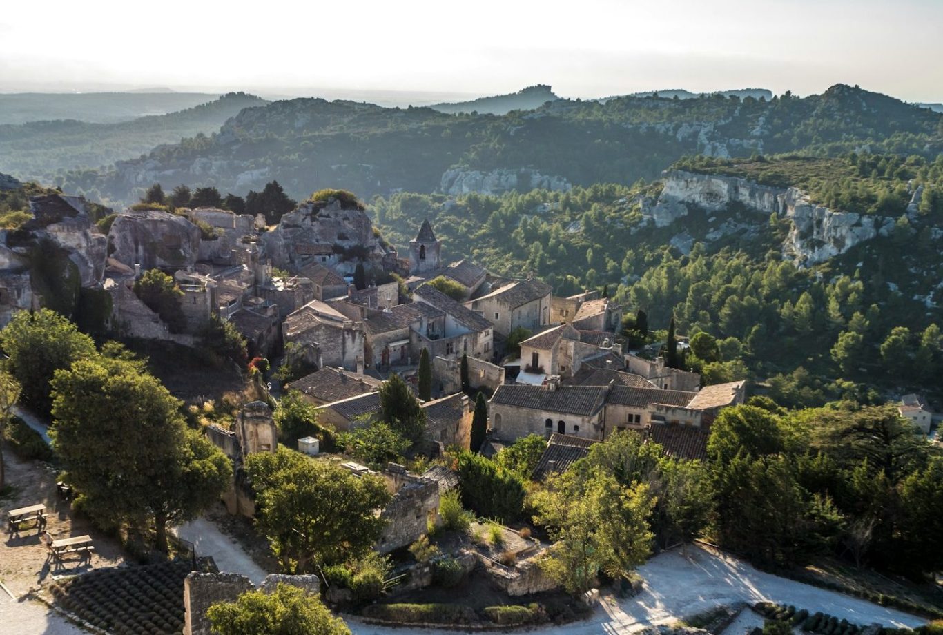 Blick auf eine malerische Landschaft mit einem historischen Dorf und umliegenden Hügeln.