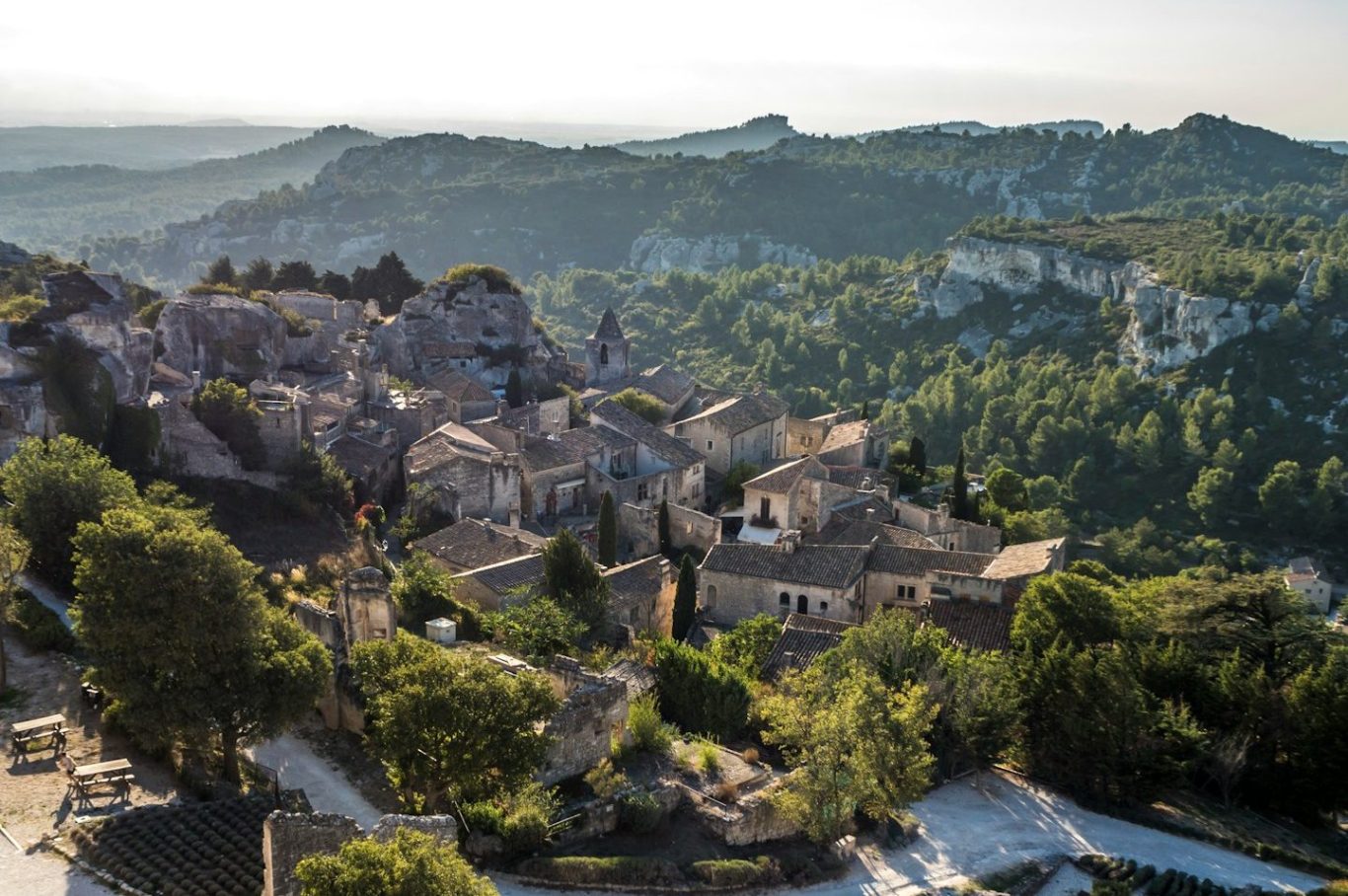 Blick auf eine malerische Landschaft mit einem historischen Dorf und umliegenden Hügeln.