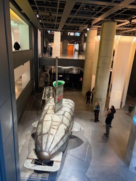 Ein U-Boot ist in einem modernen Museum ausgestellt, umgeben von Besuchern.