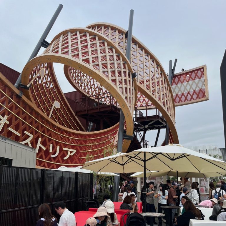 Ein modernes Gebäude mit einer geschwungenen Struktur und einem Schild für Österreich.