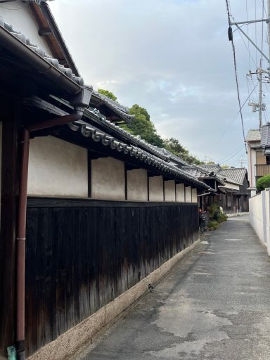 Enge Gasse zwischen traditionellen japanischen Holzhäusern mit schwarzer Wand.