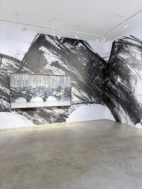 Moderne Galerie mit großformatiger Schwarz-Weiß-Wandmalerei und einem Gemälde.